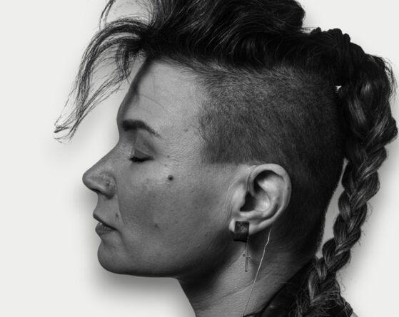 Black and white image of woman wearing cuff earring with chain in silver